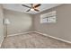 Comfortable carpeted bedroom featuring a ceiling fan, large window and a lamp at 436 Pluto Ct, Lone Tree, CO 80124