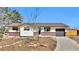 Ranch-style home with a charming brick facade, attached garage, and a well-maintained front yard on a sunny day at 436 Pluto Ct, Lone Tree, CO 80124