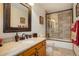 Well-lit bathroom with granite vanity, framed mirror, tile flooring, and a bathtub with glass door at 4063 S Lisbon Way, Aurora, CO 80013