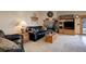 Comfortable living room with a brick fireplace, black leather furniture and a wooden entertainment center at 4063 S Lisbon Way, Aurora, CO 80013