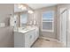 Bright bathroom featuring a double vanity with white cabinets, solid surface counters, and tile floors at 2186 Prairie Smoke Dr, Monument, CO 80132