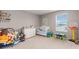 Bright bedroom featuring a crib, toys, a window, and neutral walls and carpeting at 2186 Prairie Smoke Dr, Monument, CO 80132