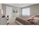 Bedroom featuring a television, queen bed, two windows, and neutral walls and carpeting at 2186 Prairie Smoke Dr, Monument, CO 80132