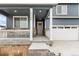Inviting front porch with seating area, leads to a two car garage and well-maintained entryway at 2186 Prairie Smoke Dr, Monument, CO 80132