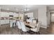 Open kitchen and dining area with white cabinets, stainless appliances, modern light fixtures, and hardwood floors at 2186 Prairie Smoke Dr, Monument, CO 80132