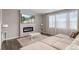 Cozy living room with fireplace, TV, modern lighting, and lots of natural light from large windows at 2186 Prairie Smoke Dr, Monument, CO 80132