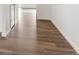 Hallway with light-colored walls and attractive laminate flooring, providing a seamless transition between rooms at 759 N Deer Park St, Watkins, CO 80137