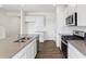 Modern kitchen with stainless steel appliances, gray countertops, and hardwood floors at 759 N Deer Park St, Watkins, CO 80137