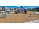 Community playground featuring climbing structures, swings, and a slide, surrounded by woodchips and newer construction homes at 759 N Deer Park St, Watkins, CO 80137