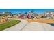Community playground with modern play structures, swings and slide for , near homes in a planned community at 759 N Deer Park St, Watkins, CO 80137
