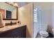 This bathroom features a separated shower stall, a dark vanity, and a large mirror at 1559 Elm St, Denver, CO 80220