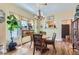 Bright and airy dining area featuring hardwood floors, a vintage style chandelier, and an abundance of natural light at 1559 Elm St, Denver, CO 80220