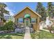 Charming single-story home featuring a quaint front porch, green shutters, and landscaped garden at 1559 Elm St, Denver, CO 80220