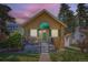Charming single-story home featuring a quaint front porch, green shutters, and landscaped garden at 1559 Elm St, Denver, CO 80220