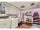 Laundry area with sink, washer, dryer, shelving and easy access to the staircase at 1559 Elm St, Denver, CO 80220