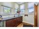 Bright laundry room with ample counter space, storage cabinets, and three windows at 1559 Elm St, Denver, CO 80220
