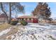 Ranch-style brick home with a red garage door and snowy yard at 2895 Poplar St, Denver, CO 80207