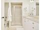 Bright bathroom featuring a glass-enclosed shower, white cabinets, and neutral tile at 150 S Harrison St # 106, Denver, CO 80209