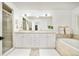 Luxurious bathroom with a double vanity, soaking tub, and glass-enclosed shower at 150 S Harrison St # 106, Denver, CO 80209