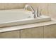 Close-up of bathtub faucet and tiled surround at 150 S Harrison St # 106, Denver, CO 80209
