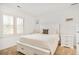 Bright bedroom with white furniture, shuttered window, and neutral walls at 150 S Harrison St # 106, Denver, CO 80209