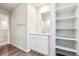 Bright bathroom features wood-look floors, white vanity with storage, and an open shelving unit at 19039 E 94Th Pl, Commerce City, CO 80022