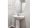 Modern powder room featuring pedestal sink, oval mirror, sleek fixtures, and light paint and wood-look flooring at 19039 E 94Th Pl, Commerce City, CO 80022