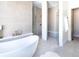 Modern bathroom with walk-in shower, freestanding tub, and elegant tile at 2442 Fox View Trl, Franktown, CO 80116
