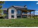 Expansive backyard view of the home's architecture, showcasing the covered patio and stone and wood exterior design at 2442 Fox View Trl, Franktown, CO 80116