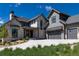 An eye-level front exterior features stone accents, gray siding, dark windows, and a driveway on a sprawling green lawn at 2442 Fox View Trl, Franktown, CO 80116