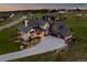 Stunning aerial view of stone home with a three-car garage and basketball hoop at dusk at 2442 Fox View Trl, Franktown, CO 80116