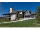 Beautiful exterior view of home featuring stone accents, attached garage, and covered deck on a sprawling green lawn at 2442 Fox View Trl, Franktown, CO 80116