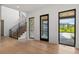 Bright foyer featuring wood floors, an elegant staircase, and views of the front yard at 2442 Fox View Trl, Franktown, CO 80116