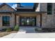 A front entrance with gray trim, dark windows, and a stone exterior with a front porch and concrete entryway at 2442 Fox View Trl, Franktown, CO 80116