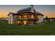 Back of the home showing the expansive decks, stone accents, and manicured lawn at 2442 Fox View Trl, Franktown, CO 80116
