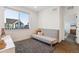Bright bedroom with a gray futon, a window with houses figurines and view, and a soft gray rug at 10165 E 59Th Ave, Denver, CO 80238