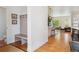 Inviting entryway featuring hardwood floors, a built-in bench, and a view to the kitchen and living area at 10165 E 59Th Ave, Denver, CO 80238