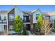 Attractive townhouse featuring a modern design, balcony, and manicured front yard at 10165 E 59Th Ave, Denver, CO 80238