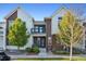 Charming two-story townhouse with a modern exterior, balcony, and well-maintained landscaping at 10165 E 59Th Ave, Denver, CO 80238
