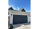 Attached two-car garage showcasing a dark gray door and white trim against a blue sky at 10165 E 59Th Ave, Denver, CO 80238