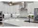 Modern kitchen featuring white cabinets, stainless steel appliances, and a stylish backsplash at 10165 E 59Th Ave, Denver, CO 80238