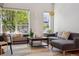 Bright living room with a gray couch, light colored rug, and large windows providing ample natural light at 10165 E 59Th Ave, Denver, CO 80238