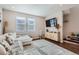 Living room with L-shaped sofa, hardwood floors, and a TV at 16057 E 47Th Pl, Denver, CO 80239