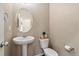 Cozy half bathroom featuring a pedestal sink, oval mirror, and neutral tones, perfect for guests at 42311 Forest Oaks Dr, Elizabeth, CO 80107