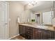 Double vanity bathroom with dark cabinets and neutral counters. A white towel is draped over each towel bar at 42311 Forest Oaks Dr, Elizabeth, CO 80107