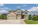 Charming two-story home featuring a stone facade and three-car garage, set under a bright, partly cloudy sky at 42311 Forest Oaks Dr, Elizabeth, CO 80107