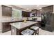 Modern kitchen with dark cabinets, granite counters, and a functional island with seating for casual dining at 42311 Forest Oaks Dr, Elizabeth, CO 80107