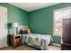 Cozy bedroom features green walls, carpet, and a window for natural light at 7883 S Windermere Cir, Littleton, CO 80120
