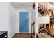 Entryway featuring hardwood floors, a blue entry door and a wooden staircase at 7883 S Windermere Cir, Littleton, CO 80120