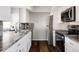 Modern kitchen featuring gray backsplash, stainless appliances, and marble countertops at 7883 S Windermere Cir, Littleton, CO 80120